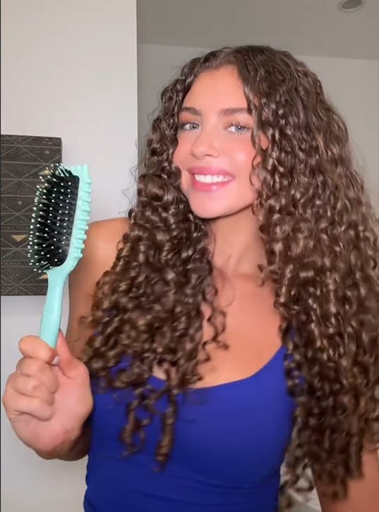 Review image of a child smiling while having their hair brushed